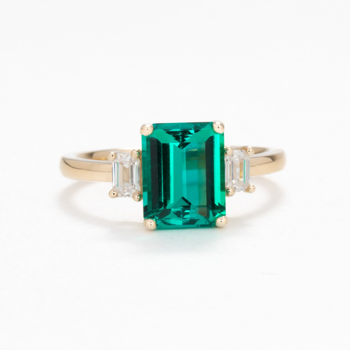 three stone engagement ring with lab emerald and diamonds