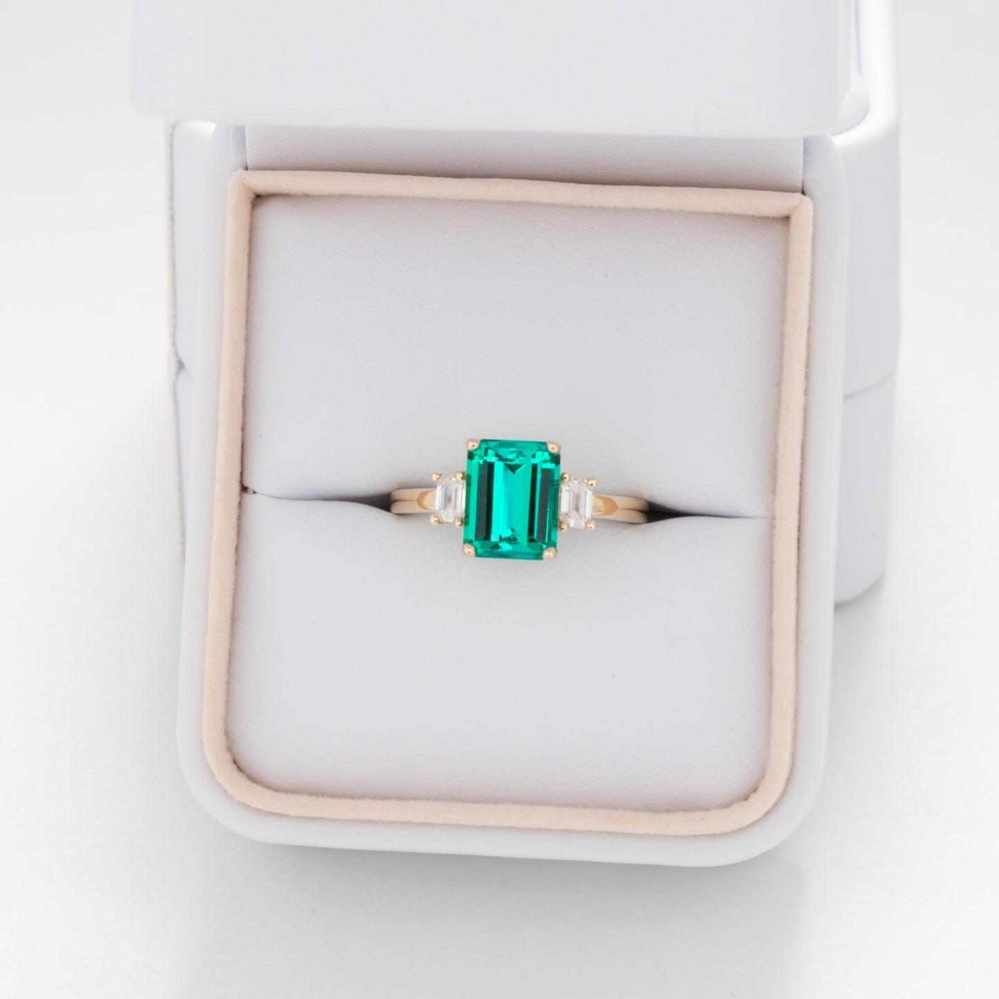 three stone engagement ring with lab emerald and diamonds