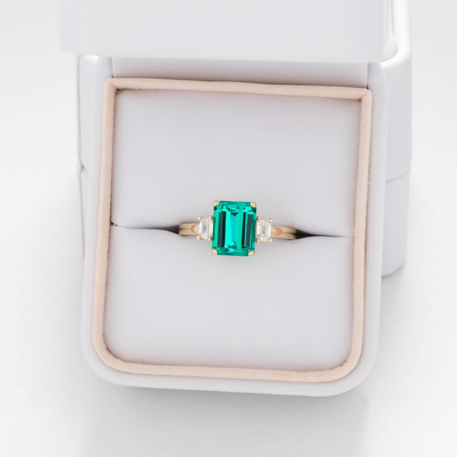 three stone engagement ring with lab emerald and diamonds