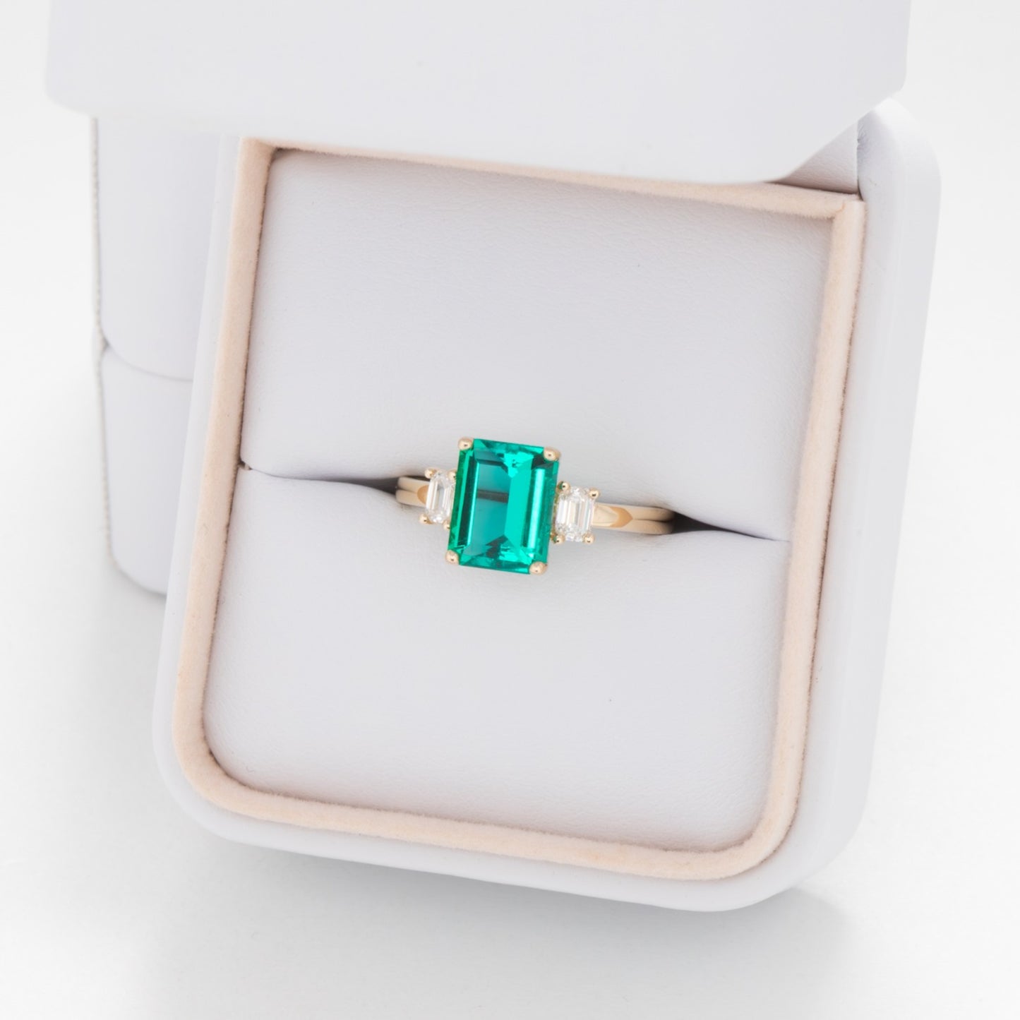 three stone engagement ring with lab emerald and diamonds