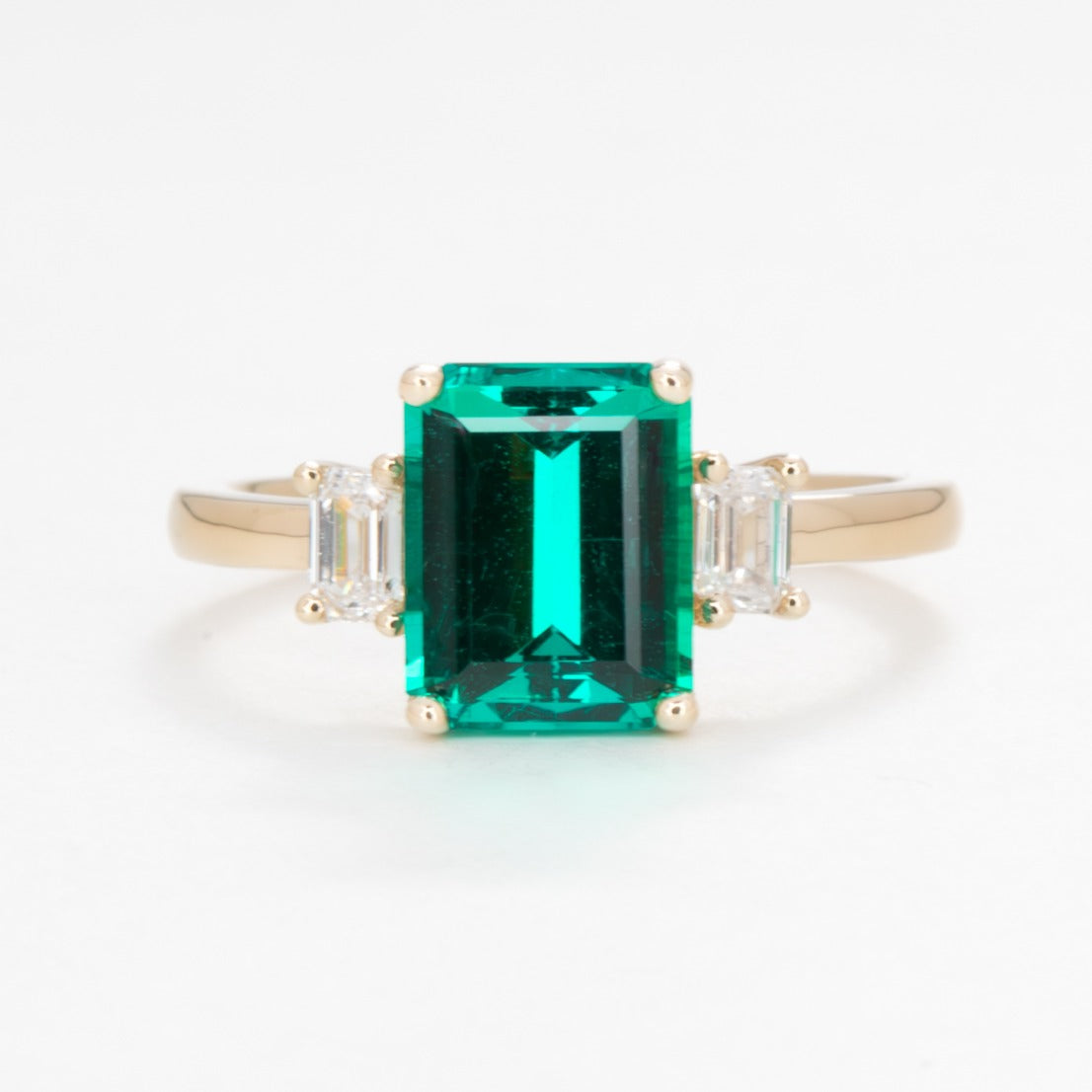 three stone engagement ring with lab emerald and diamonds