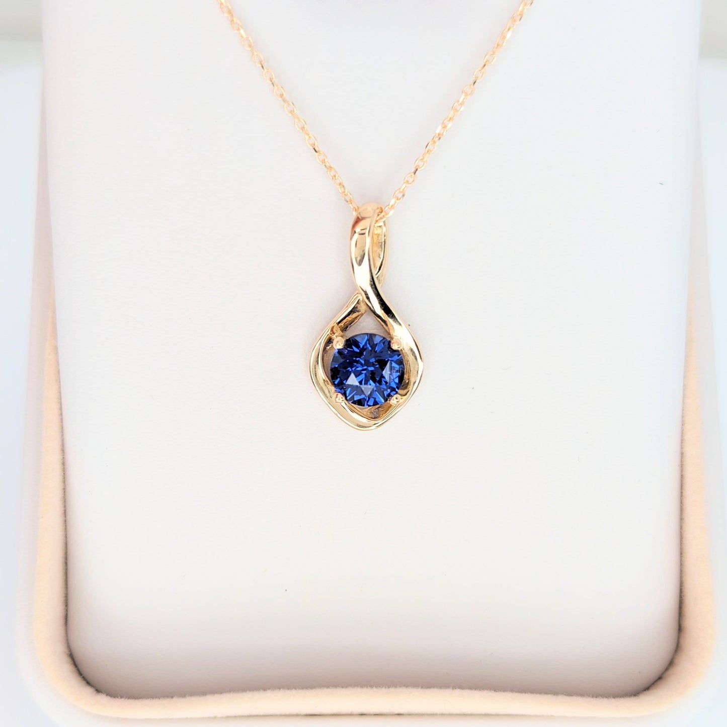 yellow gold infinity necklace with round blue lab sapphire